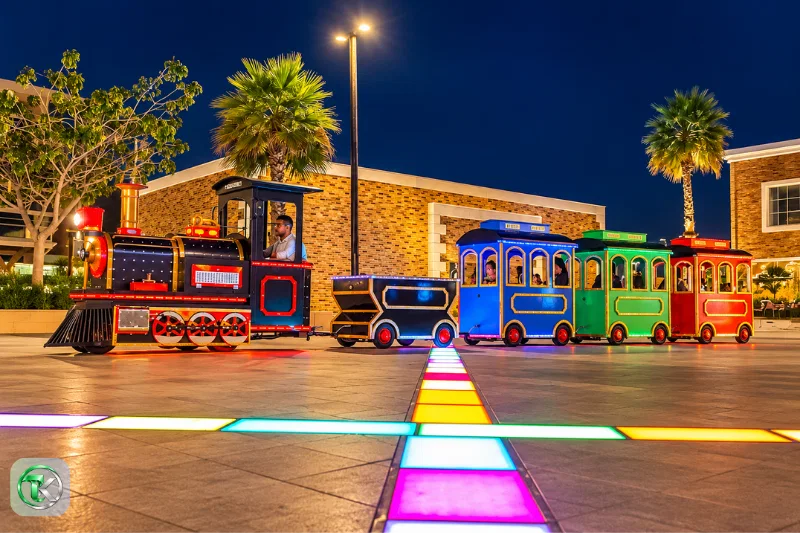 Umbrella Beach Fujairah colourful childrens train ride illuminated at night